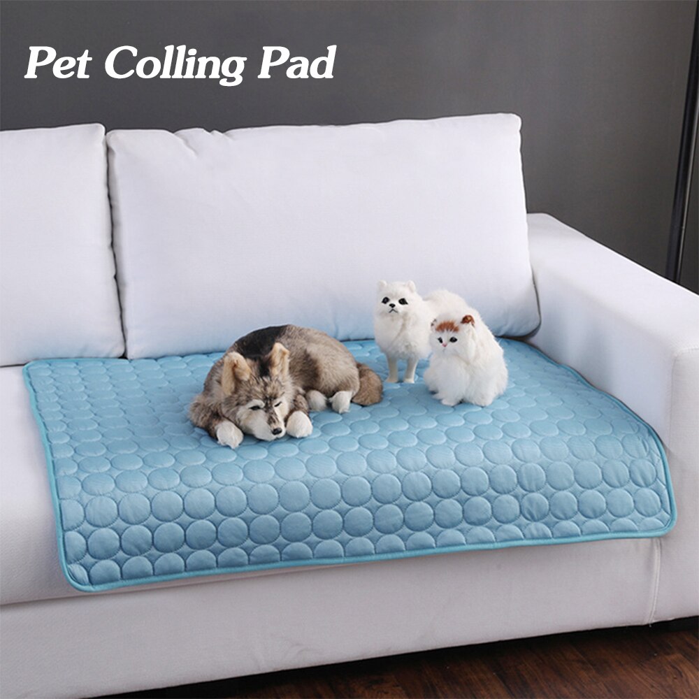 Pet cooling pad on a white couch with dogs and a cat on it, against a gray wall.